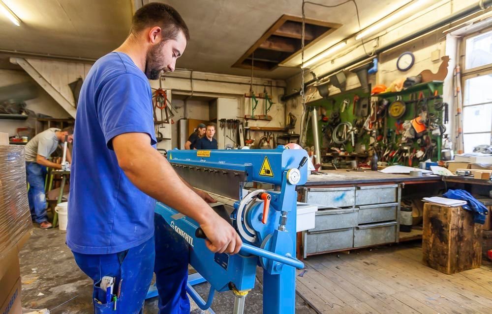 Mitarbeiter an der Blechschere in der Werkstatt