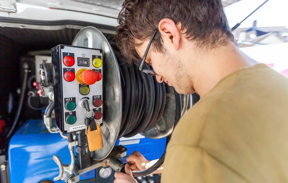 Mitarbeiter bedient die mobile Rohrreinigungsmaschine am Servicefahrzeug